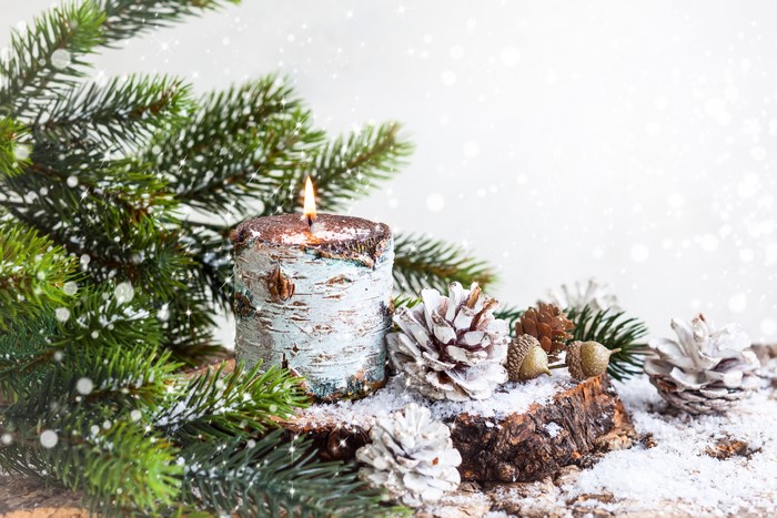 Christmas candle with pine cones and fir branches