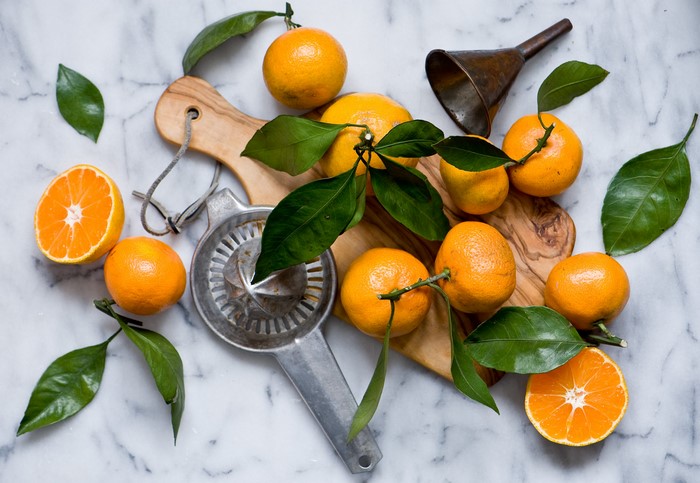 Citrus fruits with leaves and juicer