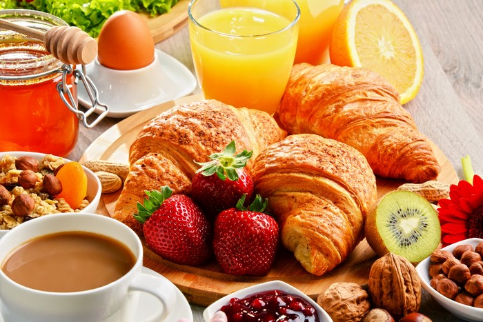 Still-life breakfast with coffee, croissants, and fruit