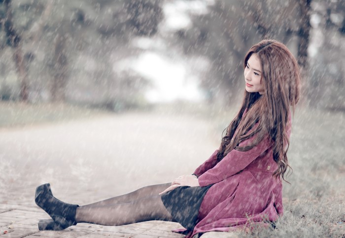 Asian woman with brown hair sitting in the rain