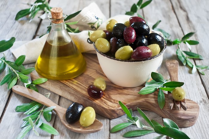 Olives and olive oil on a wooden board