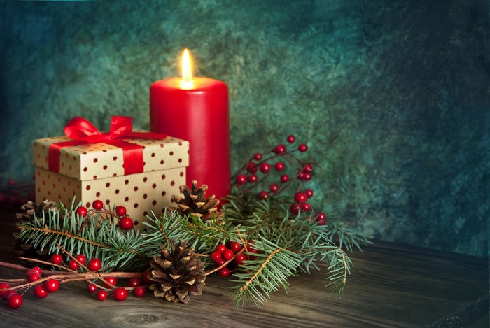 Christmas candle with gift and pine cones