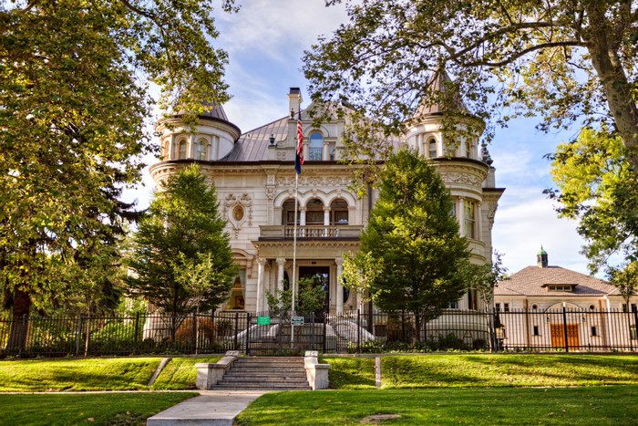 White Mansion with American Flag and Trees
