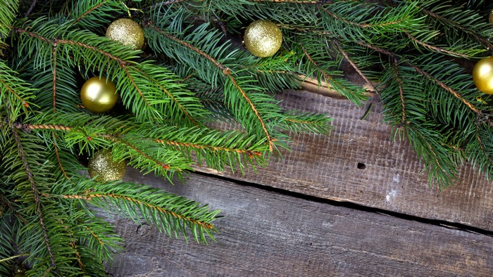 Christmas branches with golden balls on wood planks