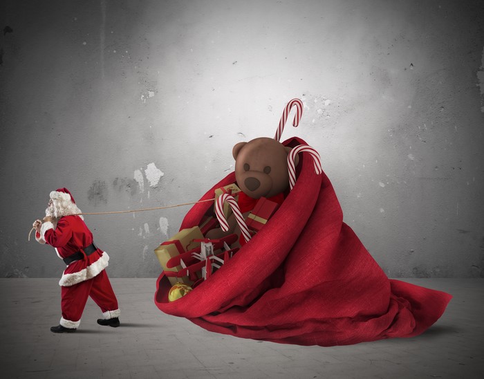 Santa Claus pulling a large sack of Christmas toys and gifts