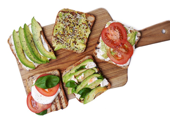 Avocado and Tomato Toasts on a Cutting Board