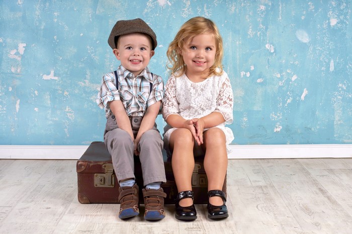 Boy and Girl Sitting on Suitcase
