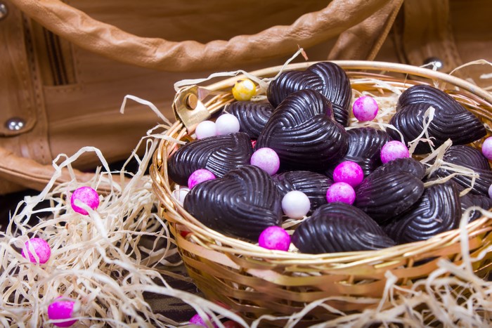 Heart-shaped chocolates and candies in a wicker basket