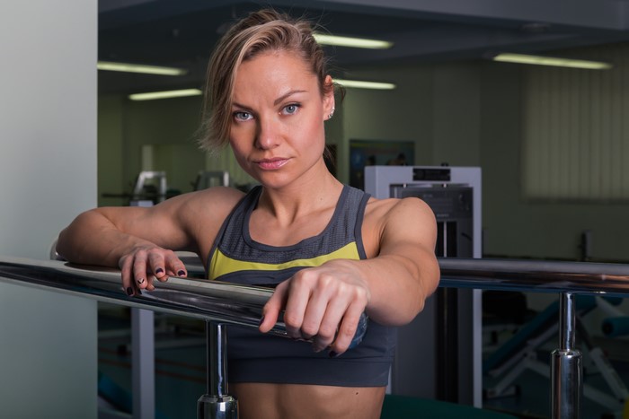 Woman in gym leaning on railing