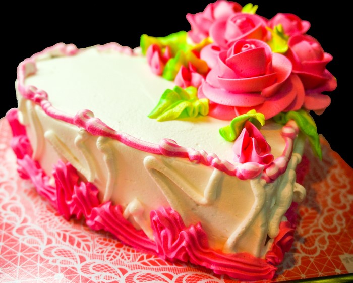 Heart-shaped cake with pink roses and frosting