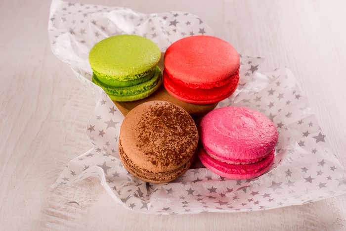 Four colorful macarons on star-patterned paper