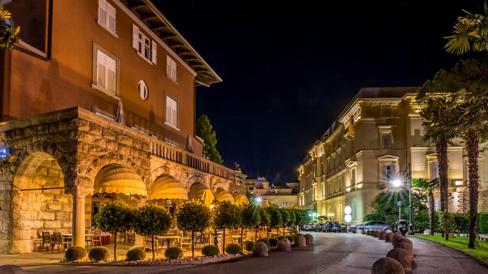 Street at night in Opatija, Croatia with buildings and trees