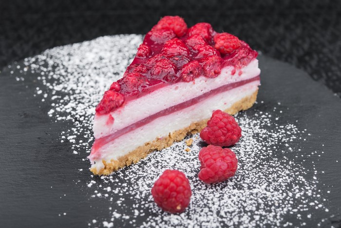 Slice of Raspberry Cheesecake with Powdered Sugar