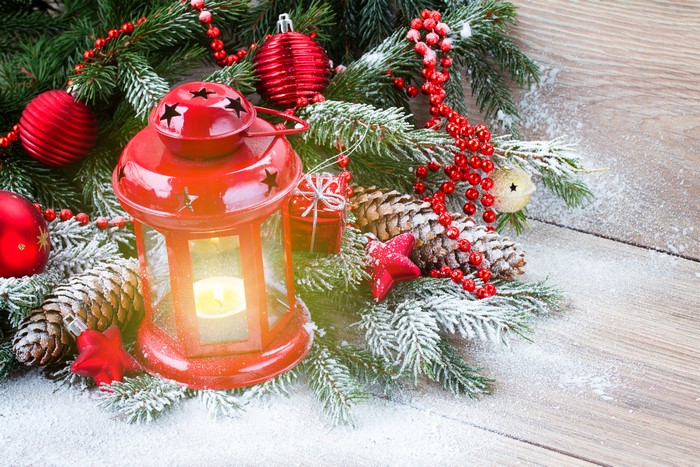 Christmas lantern with pine cones and snow on wood