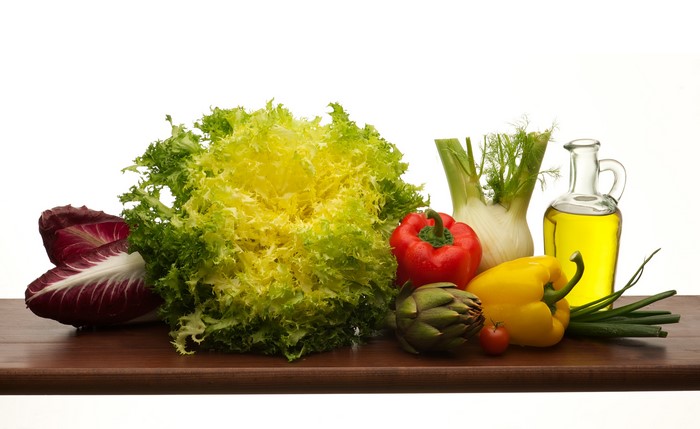 Vegetables and oil on a wooden surface