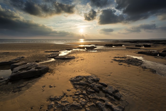 Sunset over Dunraven Bay, Wales with rocks and sand