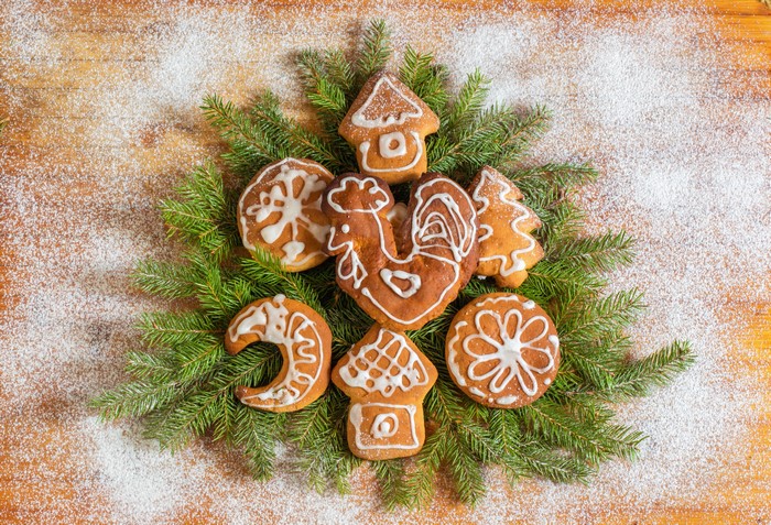 Christmas cookies arranged on pine branches with powdered sugar
