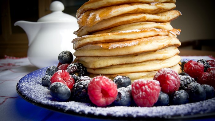 Stack of Pancakes with Berries and Powdered Sugar