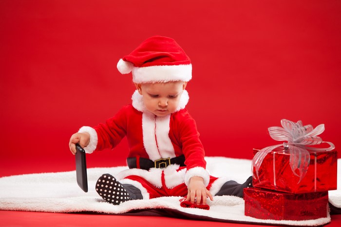 Baby in Santa Claus costume with gifts