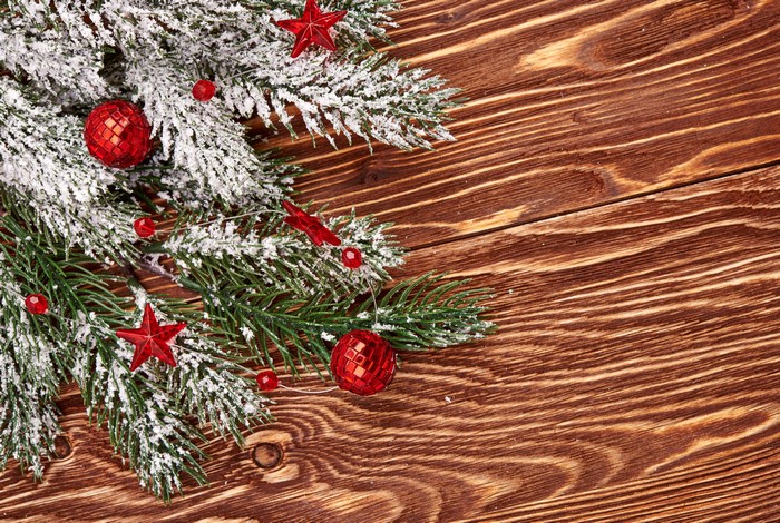Christmas branches with red ornaments on wood