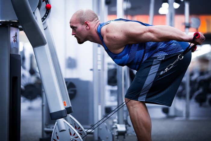 Man performing cable triceps pushdowns in a gym