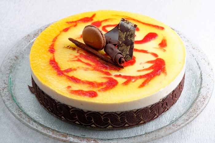 Yellow cake with red swirls and chocolate decorations