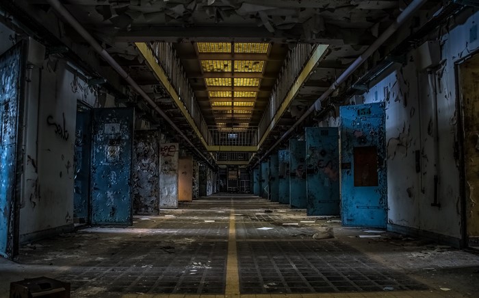 Abandoned prison corridor with cells