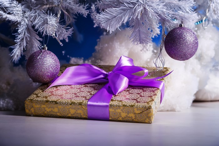 Christmas gift with purple ribbon and ornaments