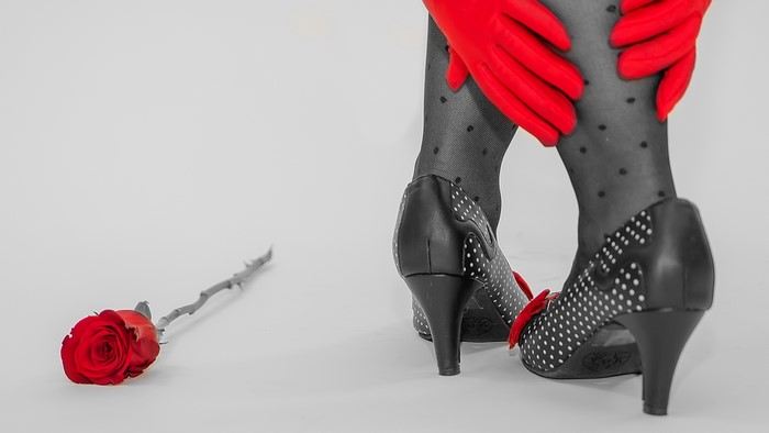Red rose and woman's legs in polka dot stockings and heels
