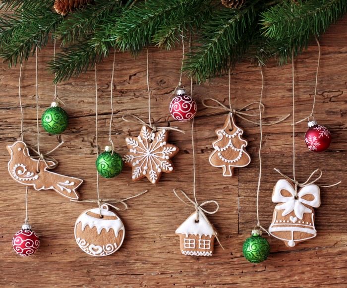Christmas gingerbread cookies and ornaments hanging on branches