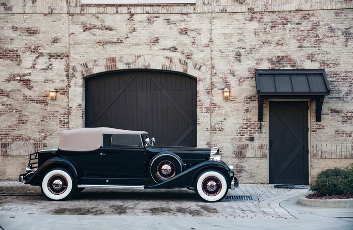 1933 Packard Twelve Convertible Victoria parked by brick building