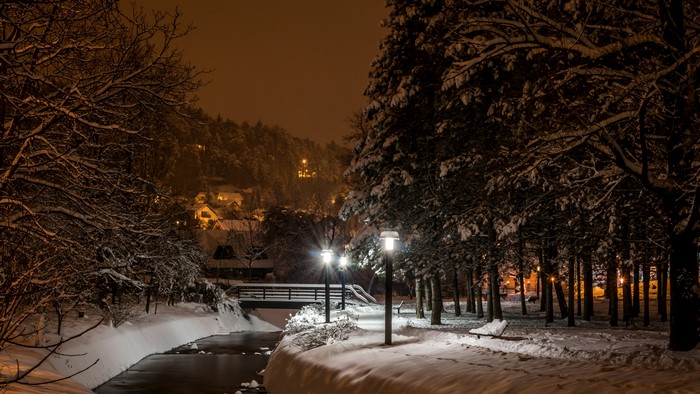 Winter night scene with snow, river, and street lights in Samobor, Croatia