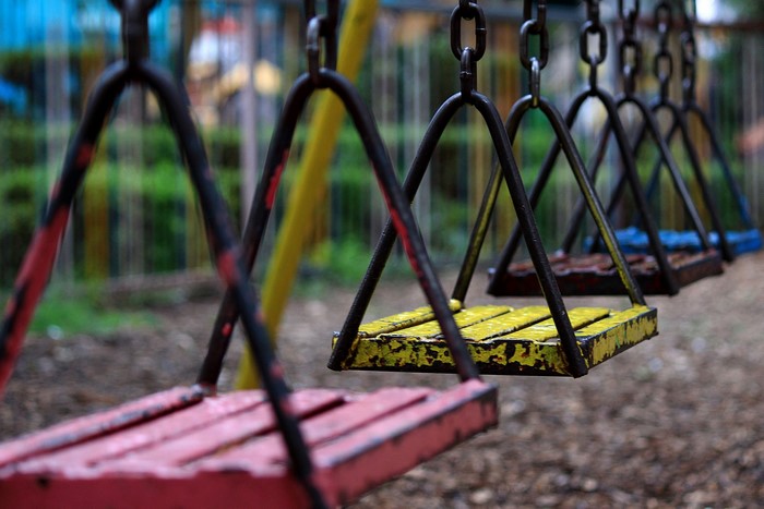 Close-up of playground swings with chains