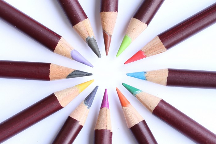 Colored pencils arranged in a circle on a white background