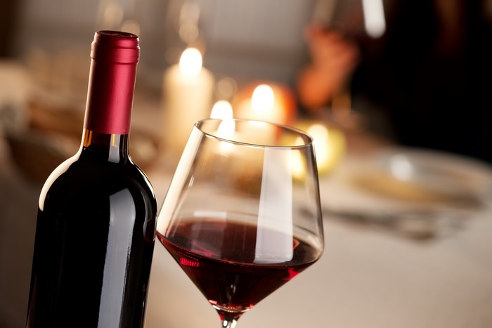 Bottle and glass of red wine with candles
