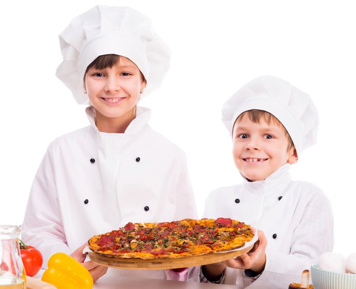 Two young chefs holding a pizza
