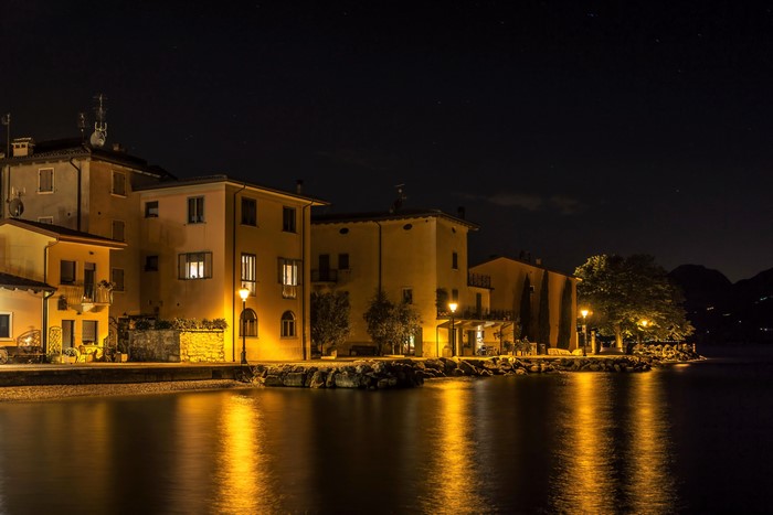 Houses by the water at night with street lights