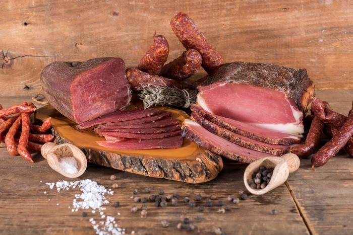 Meat products, ham, and sausage on a wooden table