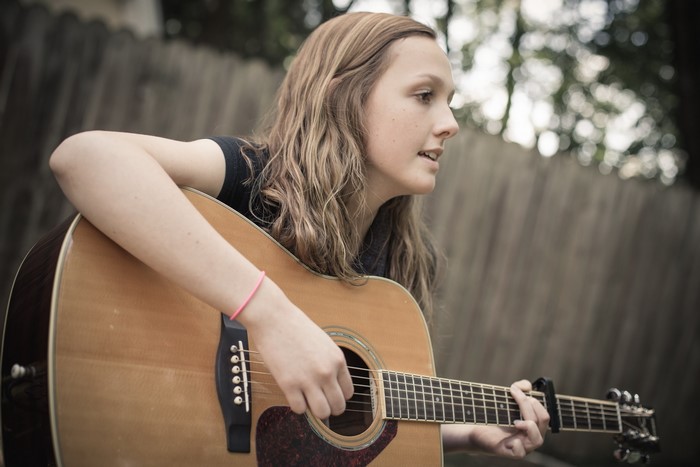 Girl playing acoustic guitar