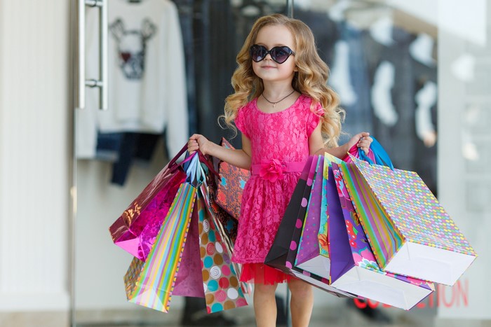 Girl in pink dress with shopping bags and sunglasses