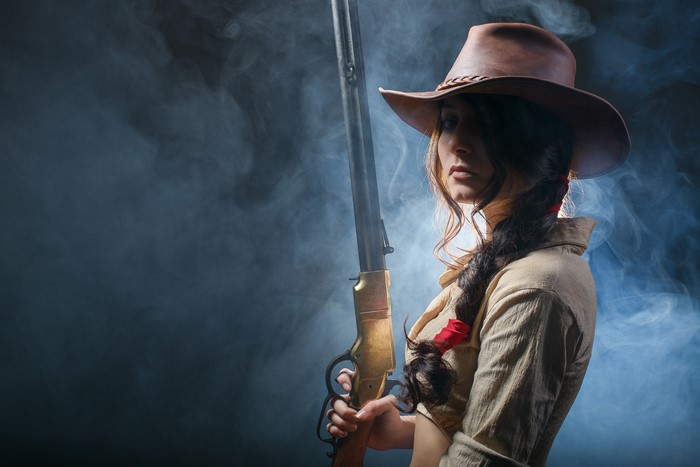 Woman in Cowboy Hat with Shotgun and Braid Hair