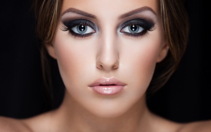 Woman with dramatic eye makeup and glossy lips