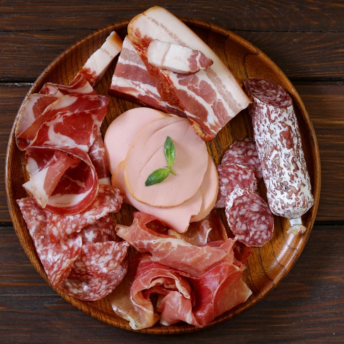 Assortment of cured meats and sausages on a wooden plate