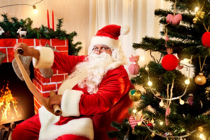 Santa Claus with a naughty or nice list by the fireplace