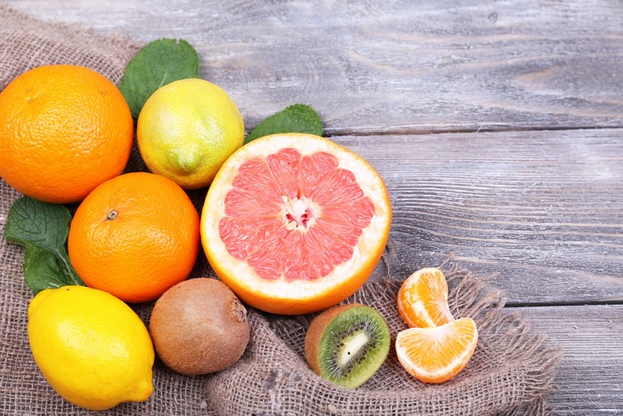 Citrus fruits and kiwi on wooden planks