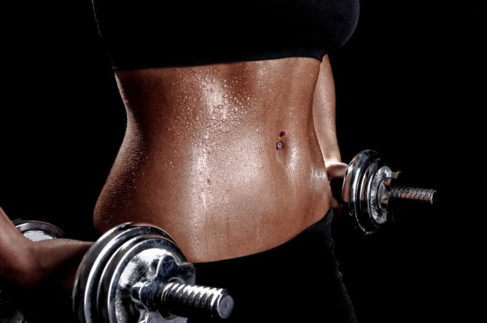 Sweaty woman with dumbbells