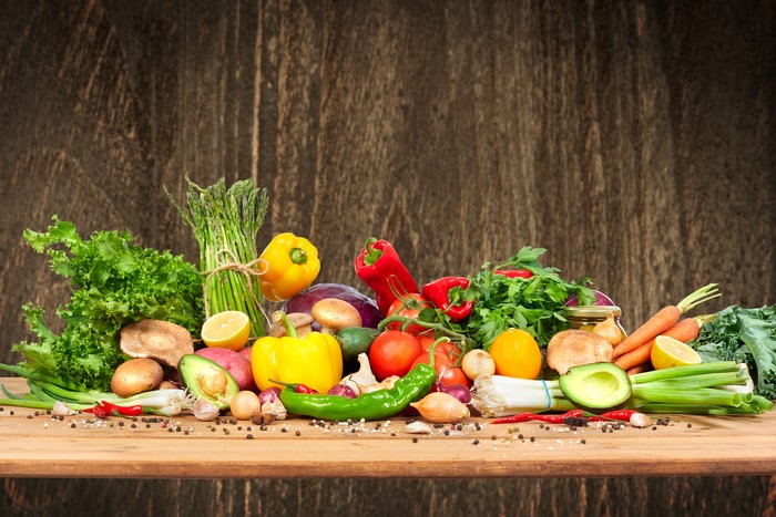 Assortment of fresh vegetables and fruits on a wooden table
