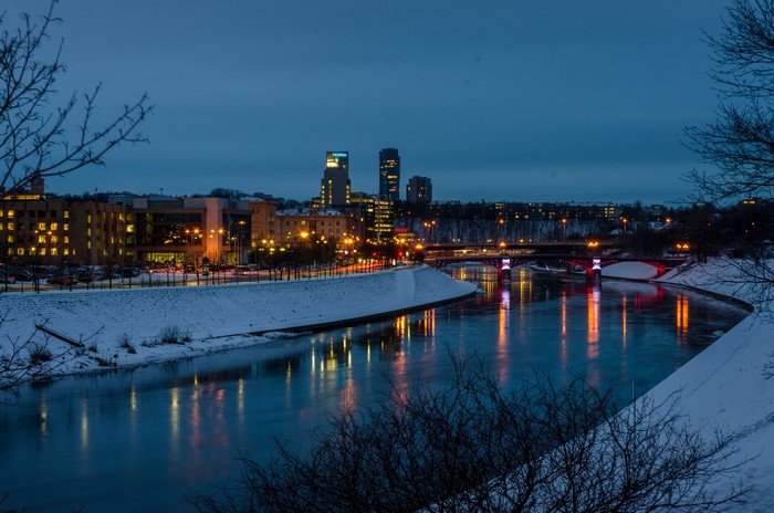 Vilnius cityscape at night with river and snow