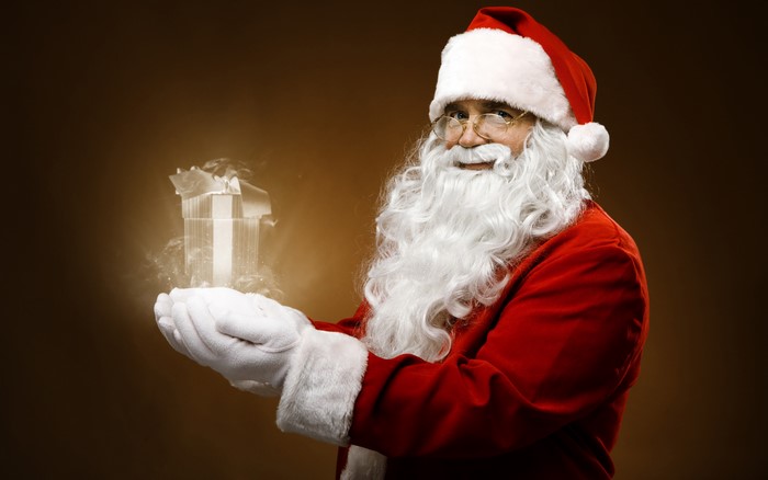 Santa Claus holding a glowing gift