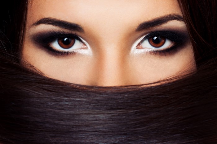 Close-up of a woman's eyes with dark makeup and hair